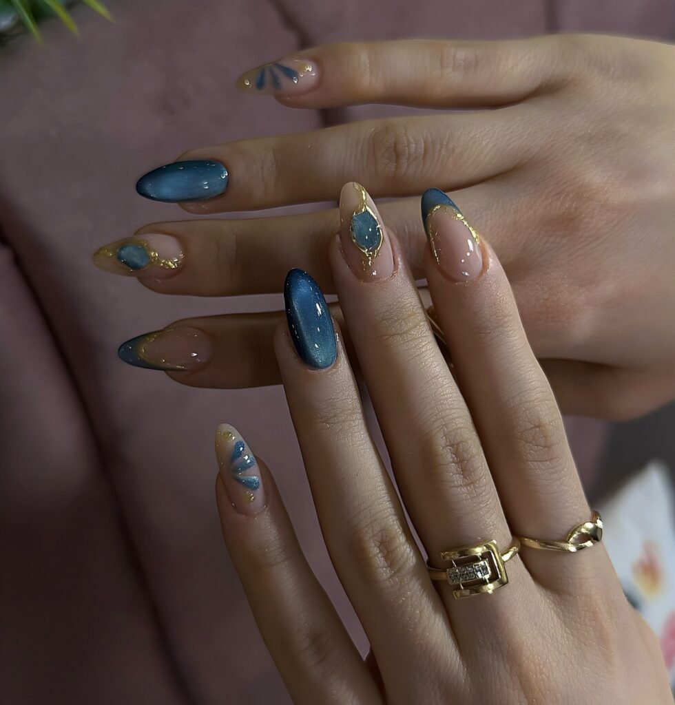 Glossy blue and nude nails with metallic gold abstract borders.  