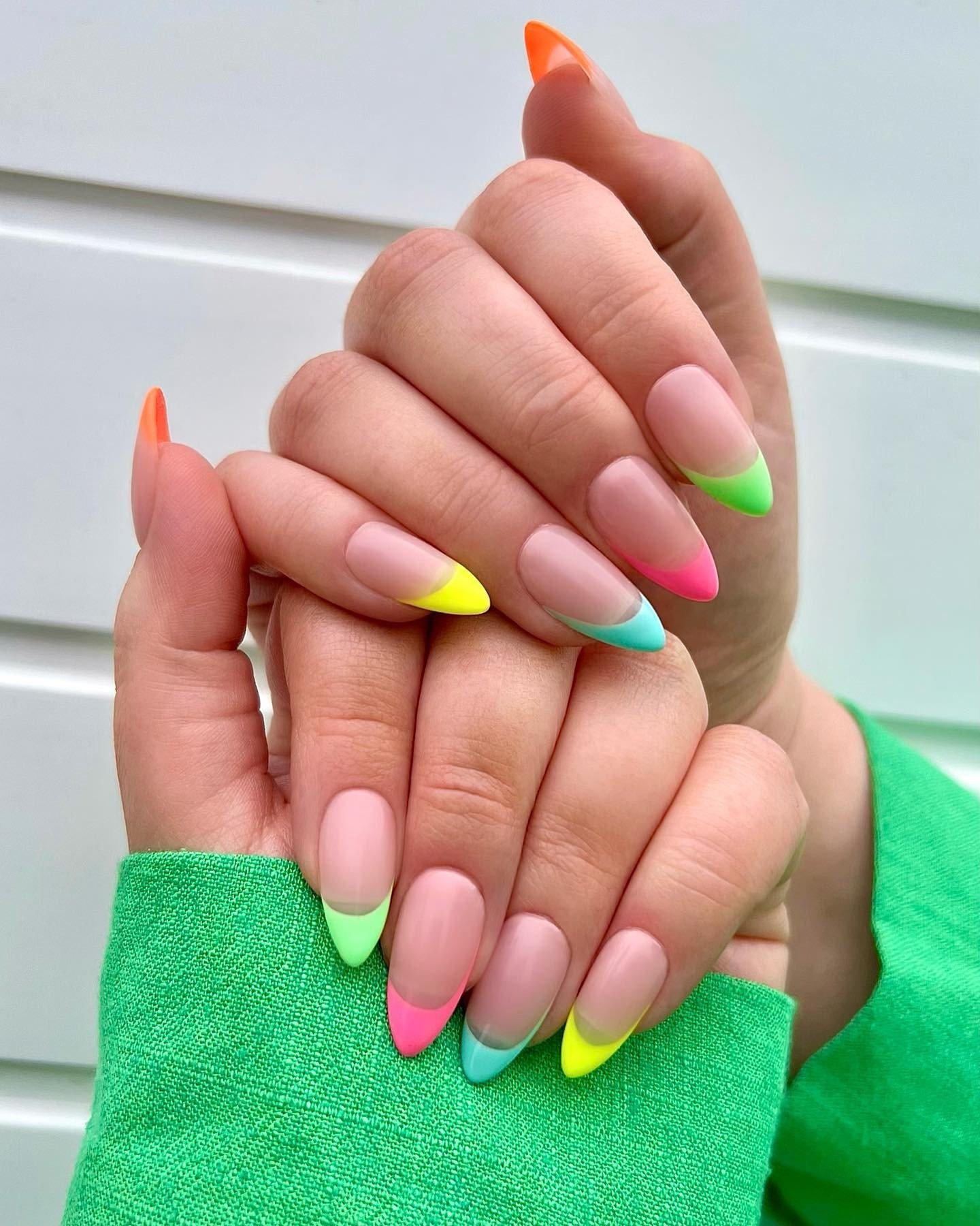 Bright neon French tip manicure with mint, yellow, pink, and lime colors on nude base