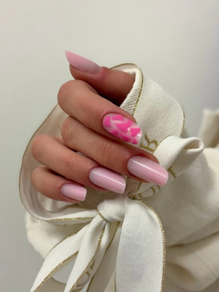 Glossy pastel pink nails with one leopard print accent nail and gift wrap.
