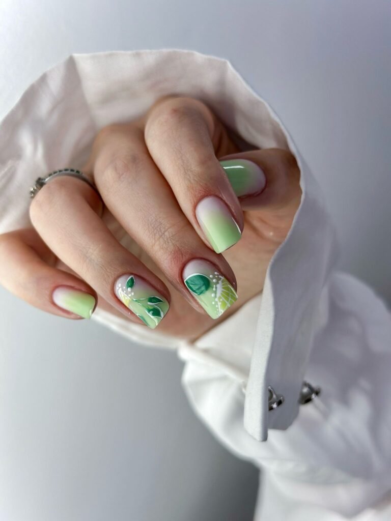 Soft pink nails with pastel green tips and delicate hand-painted flowers.  