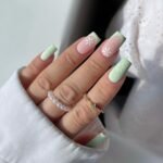 Square pastel nails with mint French tips and small white daisies.