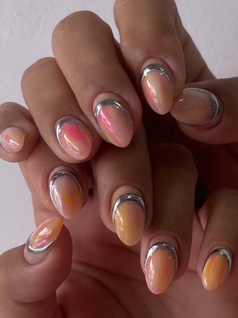 Almond nails with coral ombré centers and shiny silver outlines.