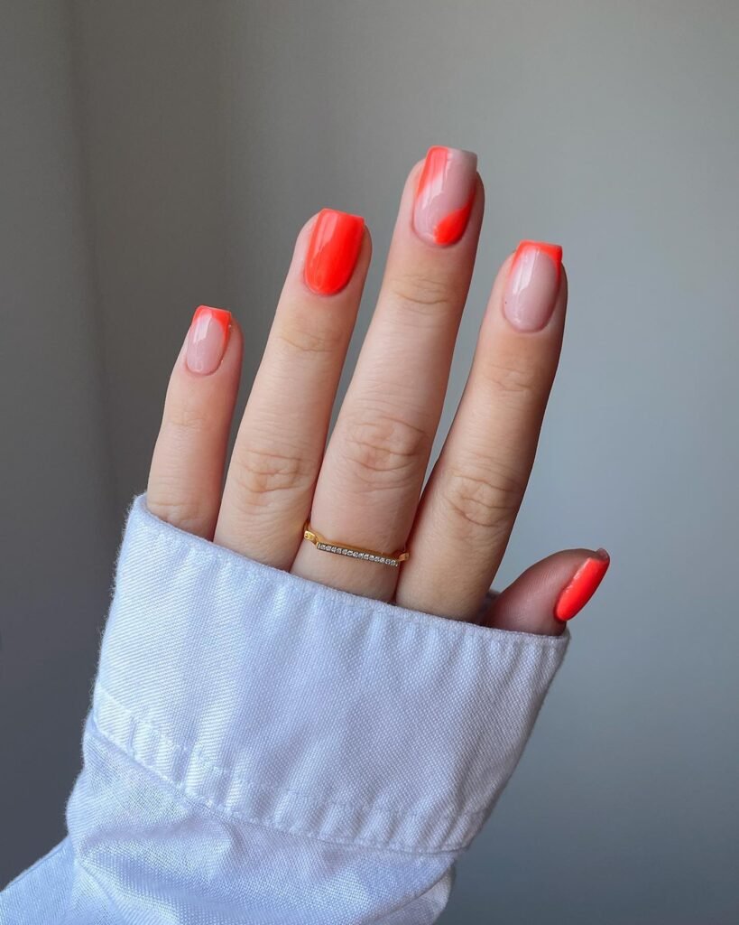 Long coral French nails with translucent nude base and abstract blocks.