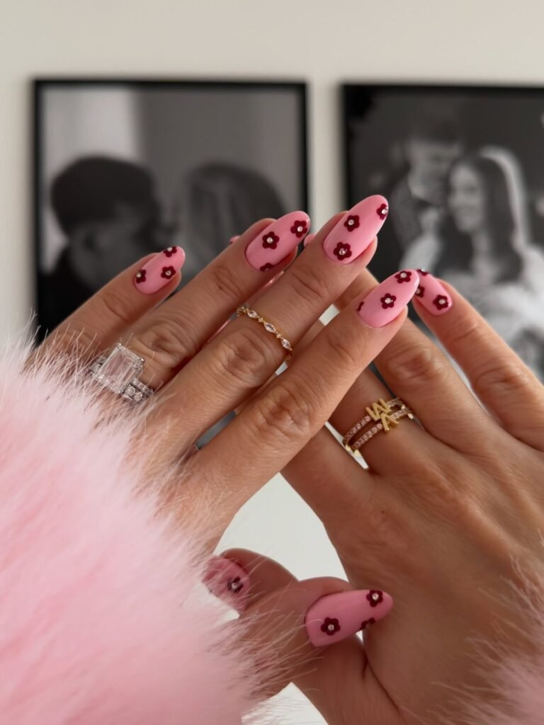 pink y2k nails with burgundy flowers and rhinestones