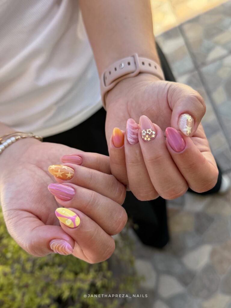 sunset y2k nails with pink yellow and star details