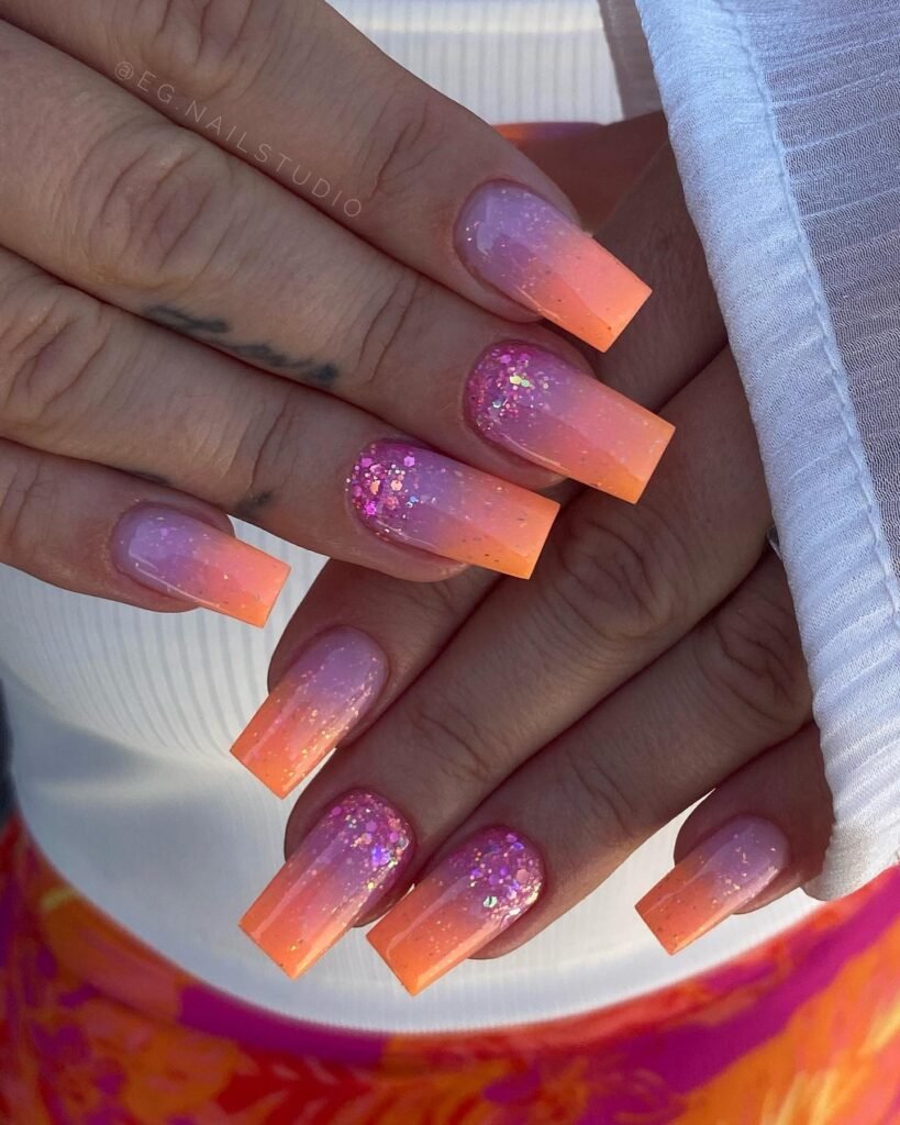 Square ombré nails fading from soft pink to orange with glitter, shimmer, and a glossy salon finish.