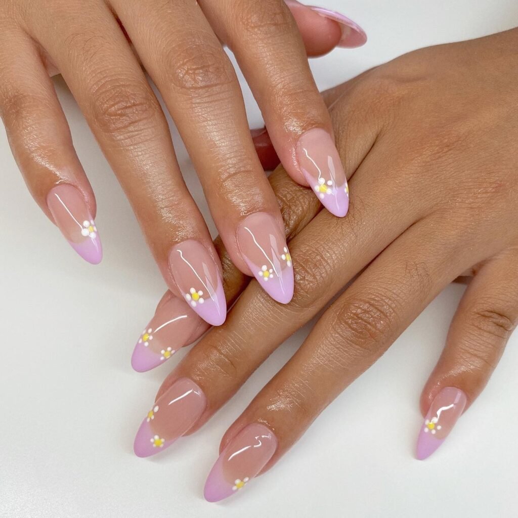 Almond nails with lilac French tips and tiny daisy accents.