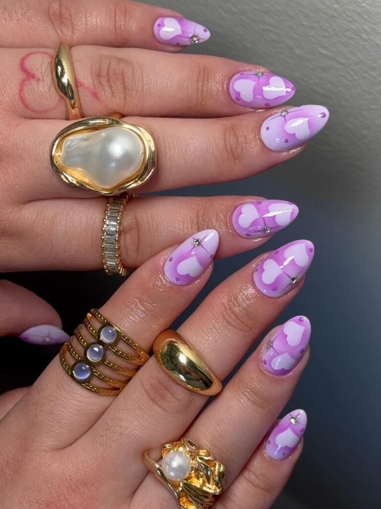 Lavender heart nails with gold rings and playful three dimensional details.