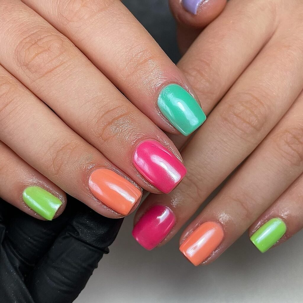 Glossy skittle manicure with coral pink mint green nails