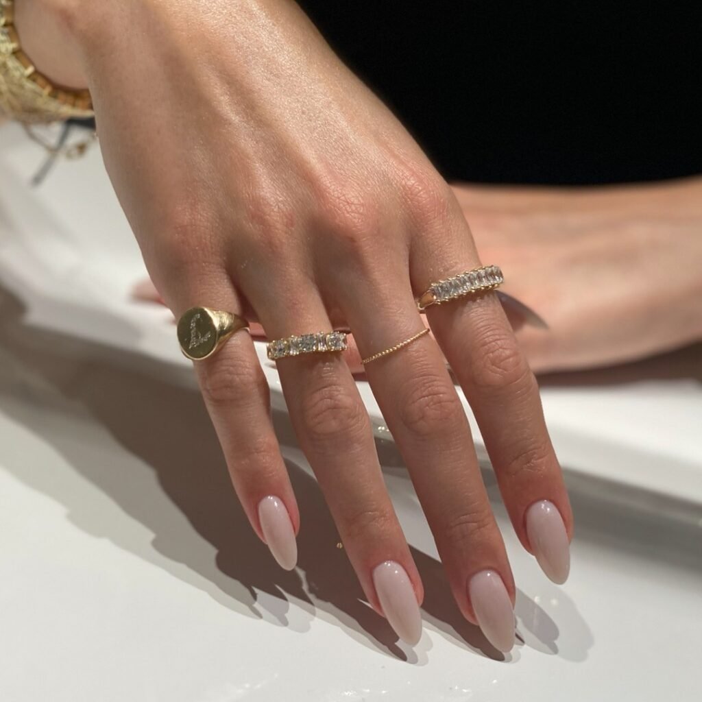 elegant invisible French almond nails with gold rings