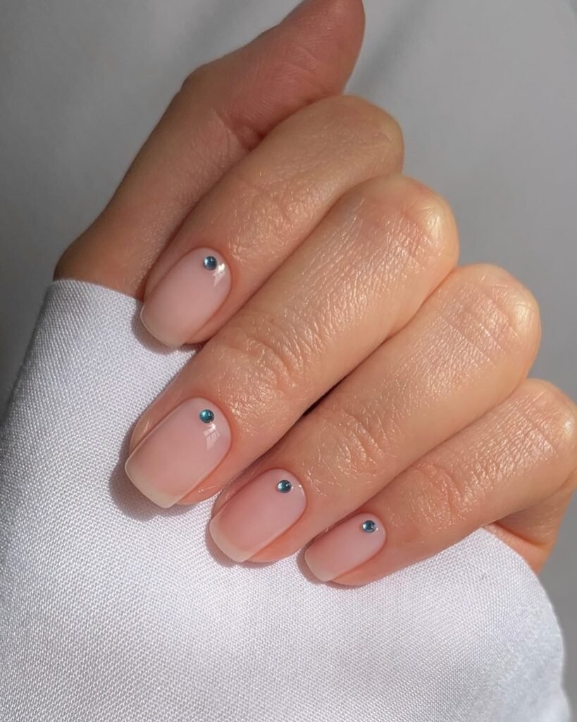 invisible French nails with tiny blue rhinestone accents