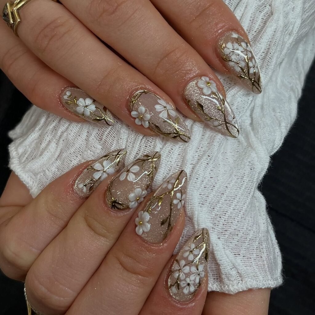 white floral June nails with gold vine accents