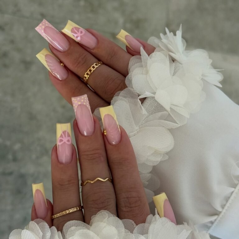 yellow French tip nails with pink bow accents