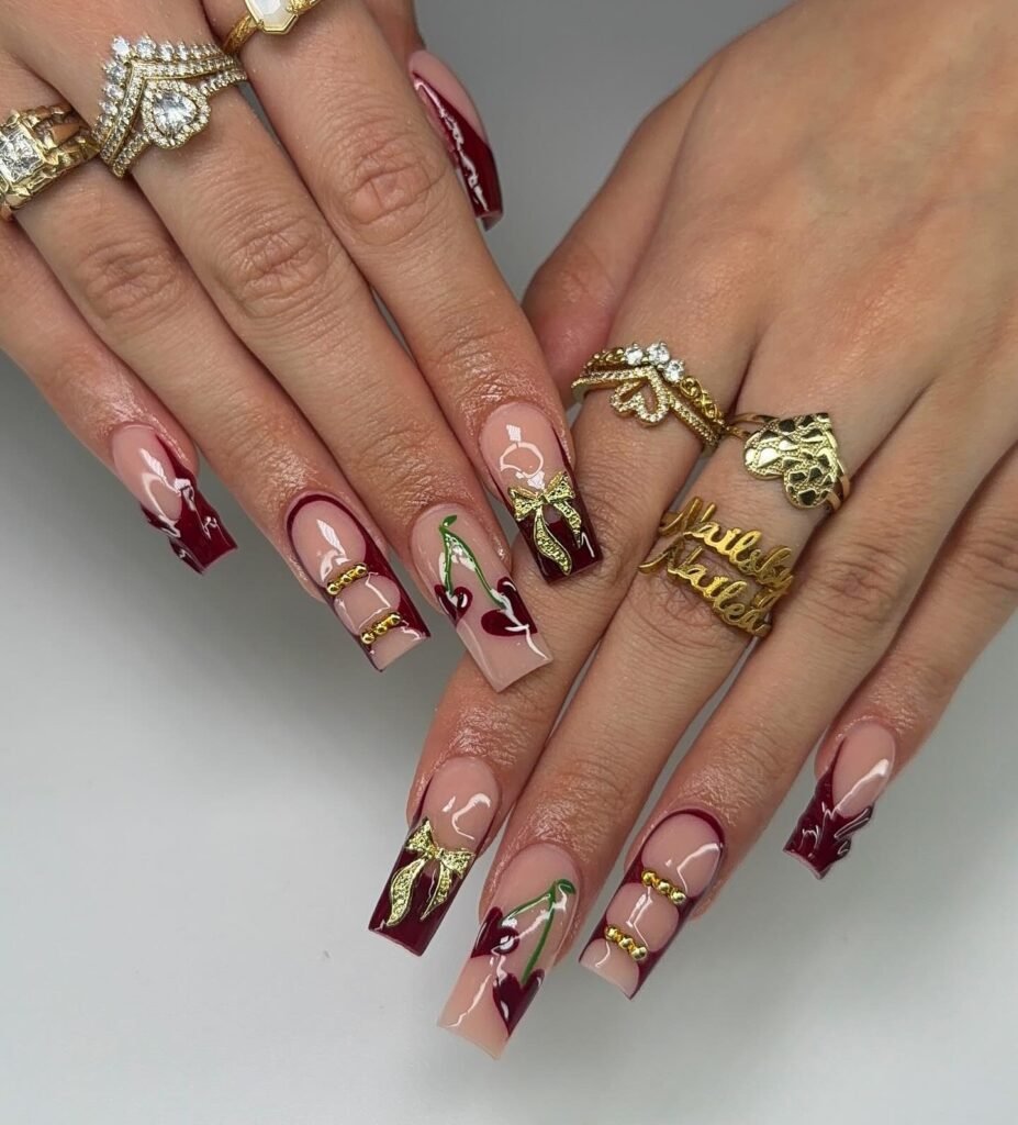 burgundy cherry nails with gold bows and glossy tips