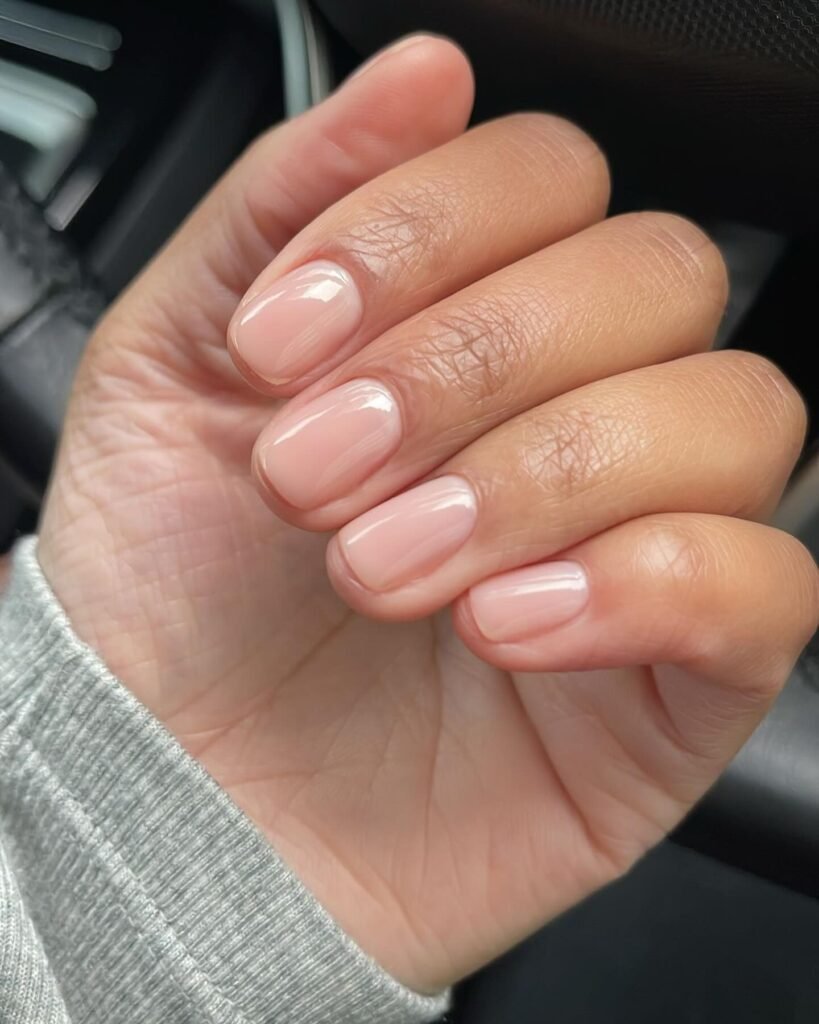 Short glossy natural nails with sheer pink polish