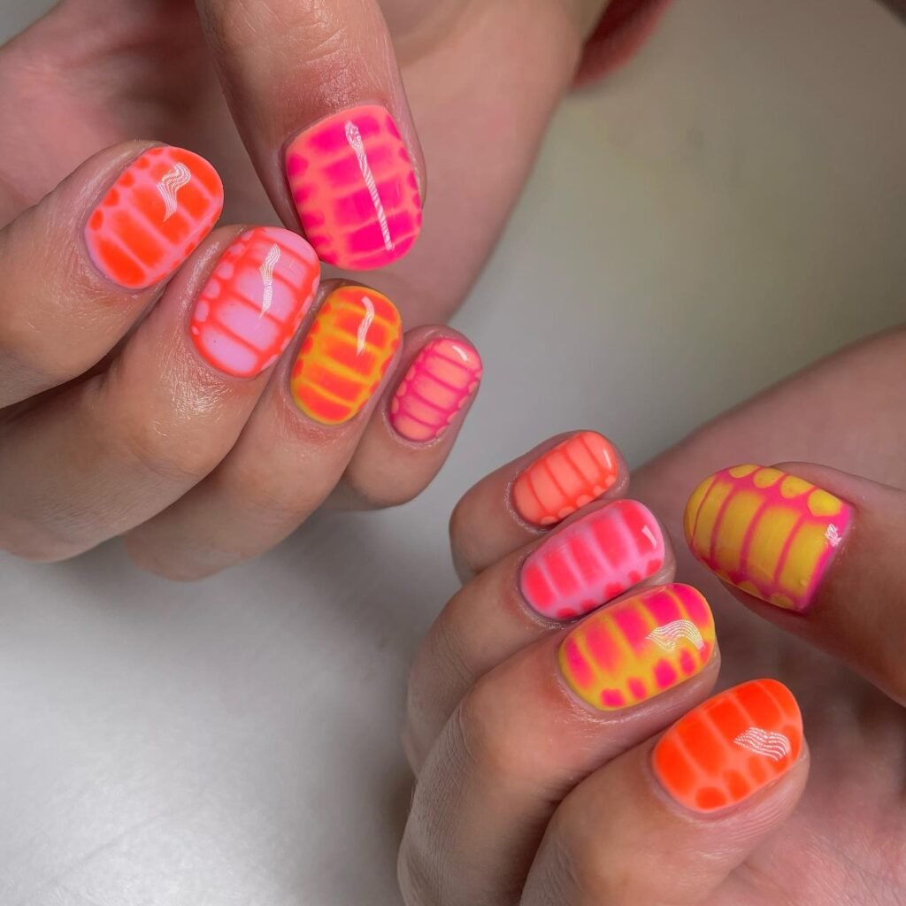 Neon coral tie-dye nails with pink and yellow patterns
