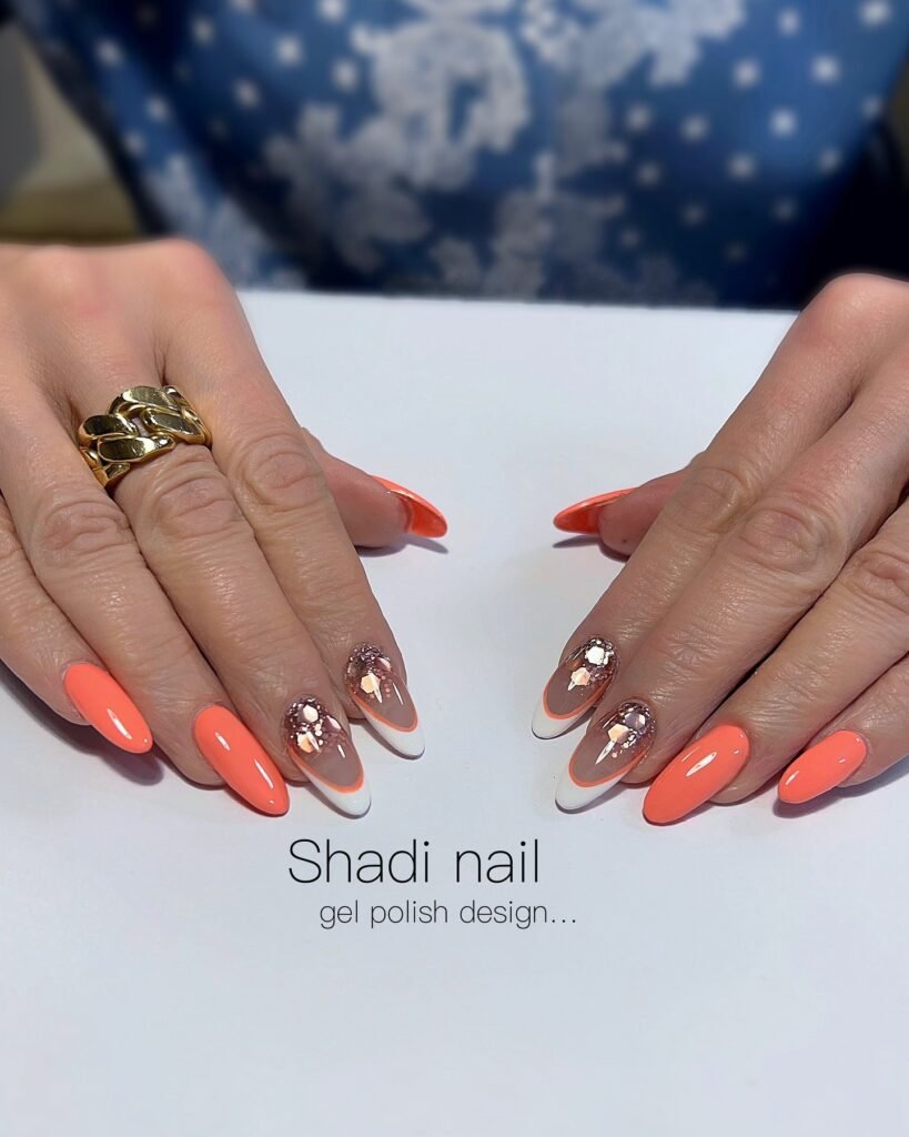 Coral orange nails with white French tips and gold accents