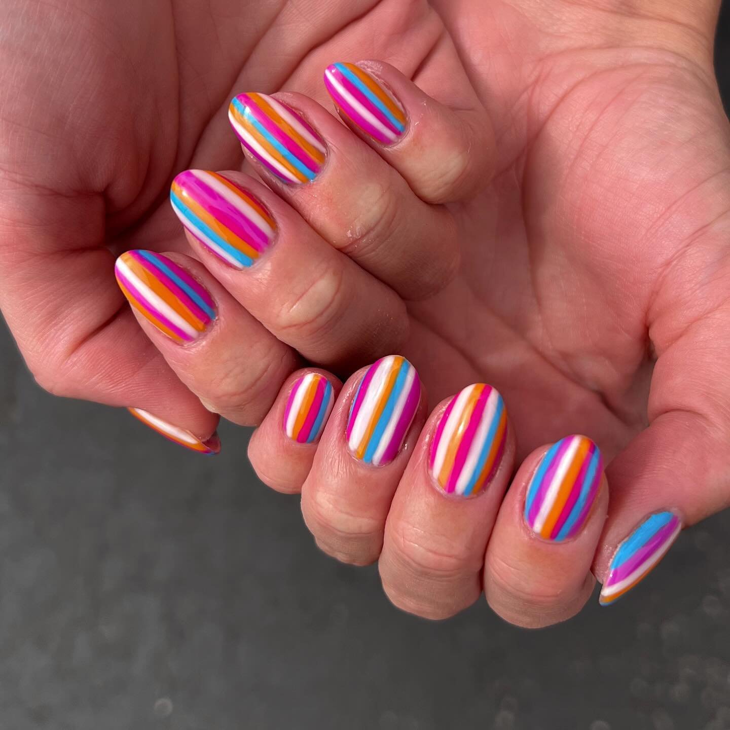 bright striped nail design with pink orange blue lines