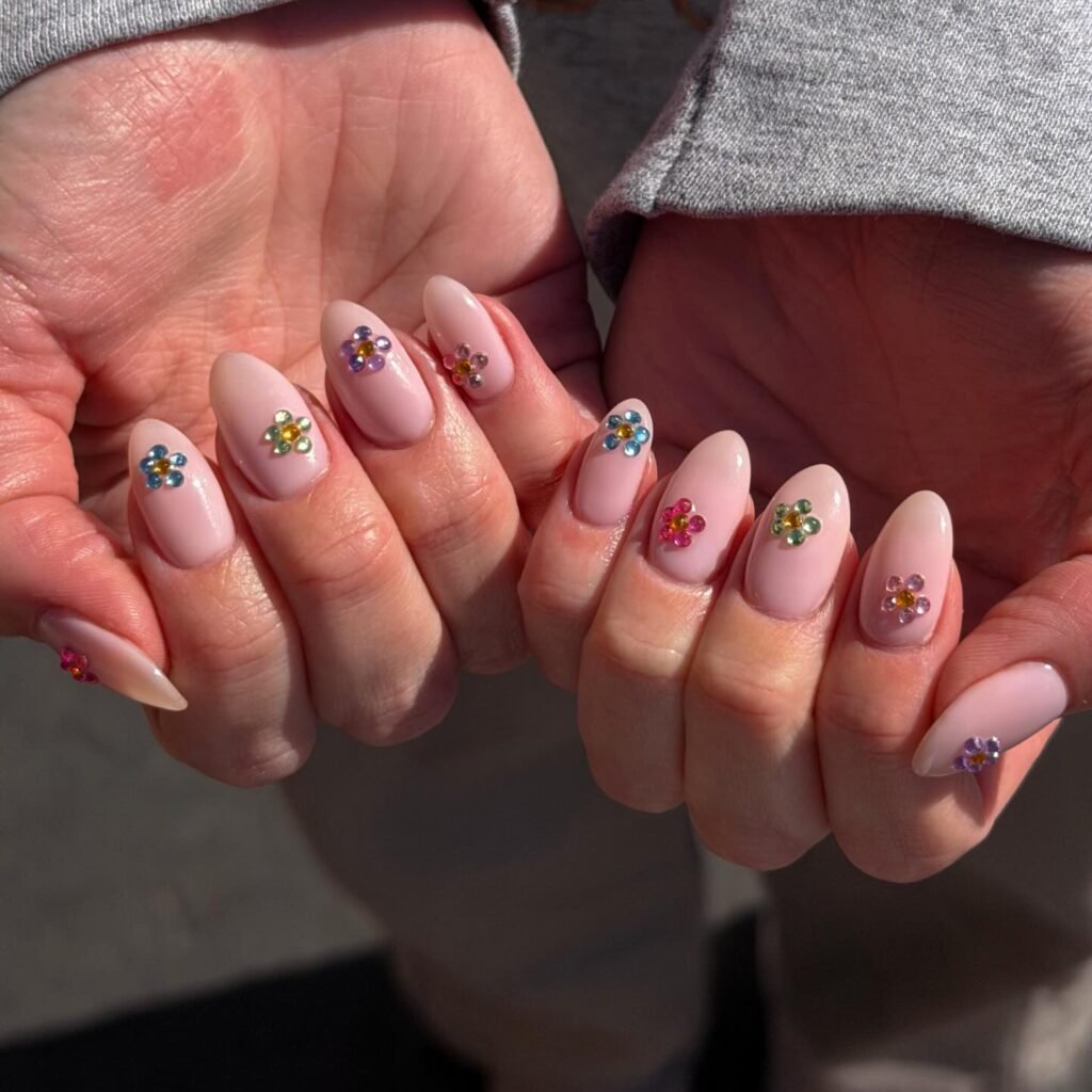 pink almond nails with colorful rhinestone flower accents